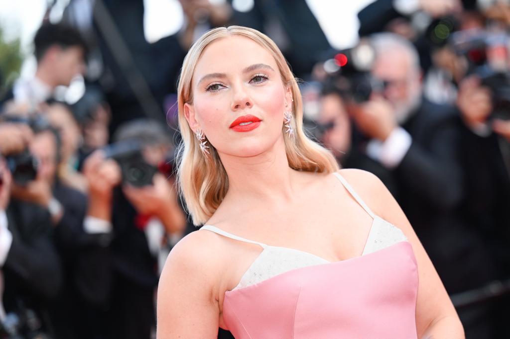 Scarlett Johansson on a red carpet in a pink and white dress